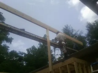 Carpenter setting a ridge beam over a new addition frame — Ice Dam Removal by Roofing Brothers in South Hadley