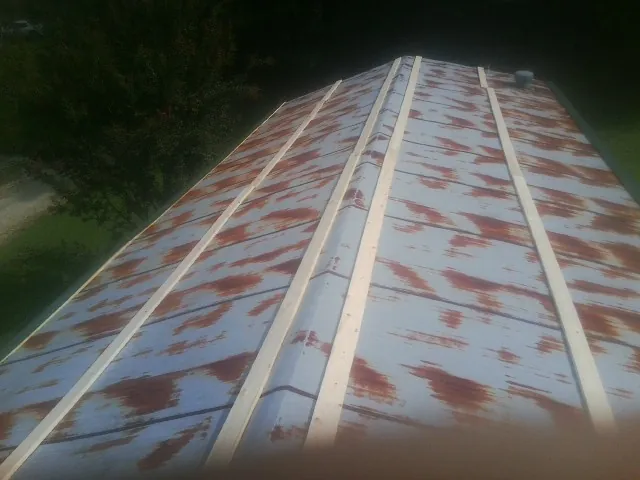 Rusted metal roof panels with new wood purlins before replacement — Storm Damage Roof Repair in South Hadley by Roofing Brothers