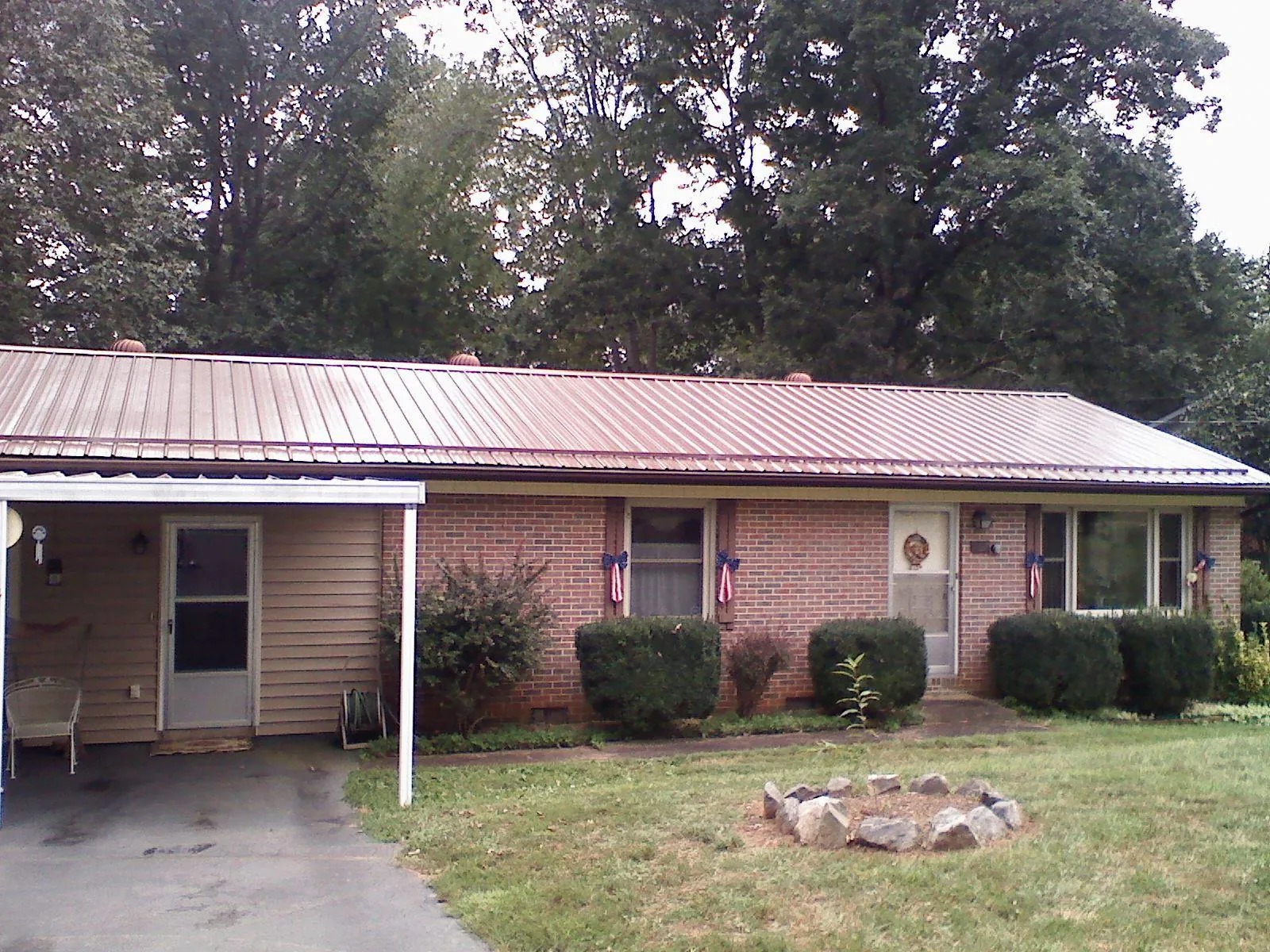 Bronze metal roof and carport on a brick ranch home — Roof Repair work by our crew in South Hadley